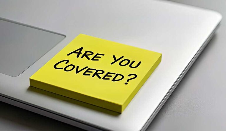 Resident reviewing insurance papers beside a phone, camera, receipts, and secure document folder.